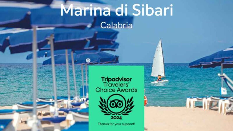Plaża Marina di Sibari w Kalabrii, z niebieskimi parasolami i żeglarzem w tle. Obecna nagroda Tripadvisor 2024.