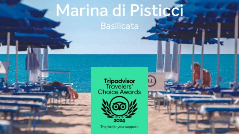 Plaża Marina di Pisticci w Basilicacie, z niebieskimi parasolami i widoczną w pierwszym planie nagrodą Tripadvisor 2024.