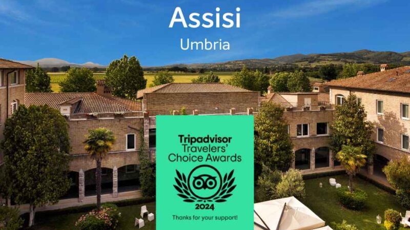 Panoramiczny widok na Asyż, Umbria, z zadbanymi ogrodami i nagrodami Tripadvisor na 2024 rok w pierwszym planie.