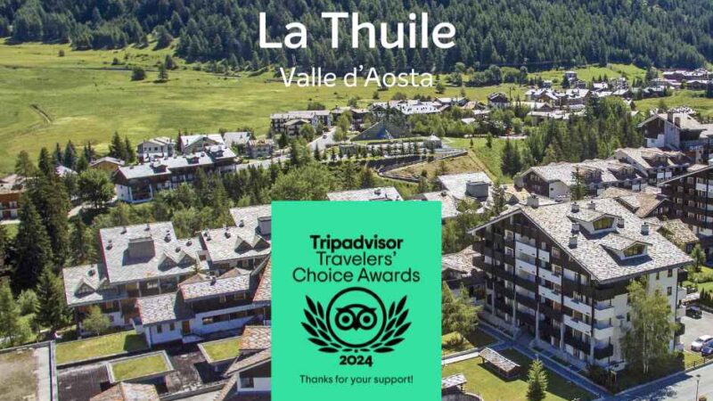 Panorama La Thuile w Dolinie Aosty, z chatkami i górami, oraz logo nagród Tripadvisor 2024.