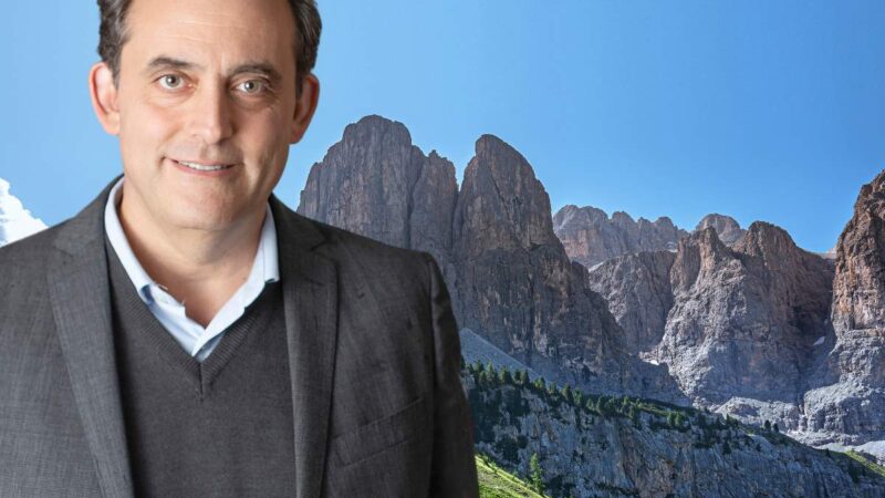 Portrait of Salvatore Piazza, Chief Operation Officer of TH Resorts, with rocky mountains in the background and a blue sky.