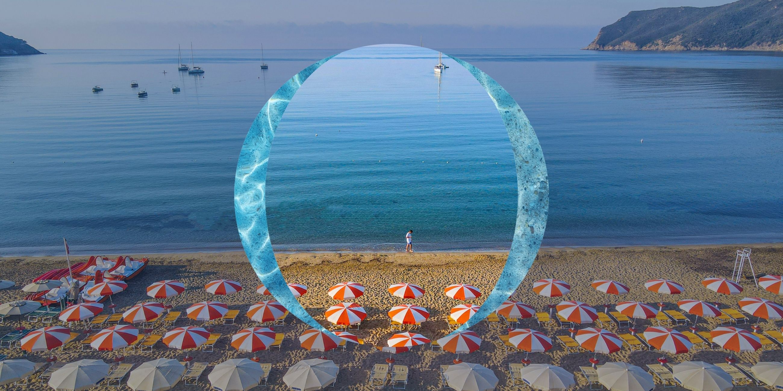 Plaża z czerwonymi i białymi parasolami, spokojne morze, łodzie i osoba spacerująca brzegiem.