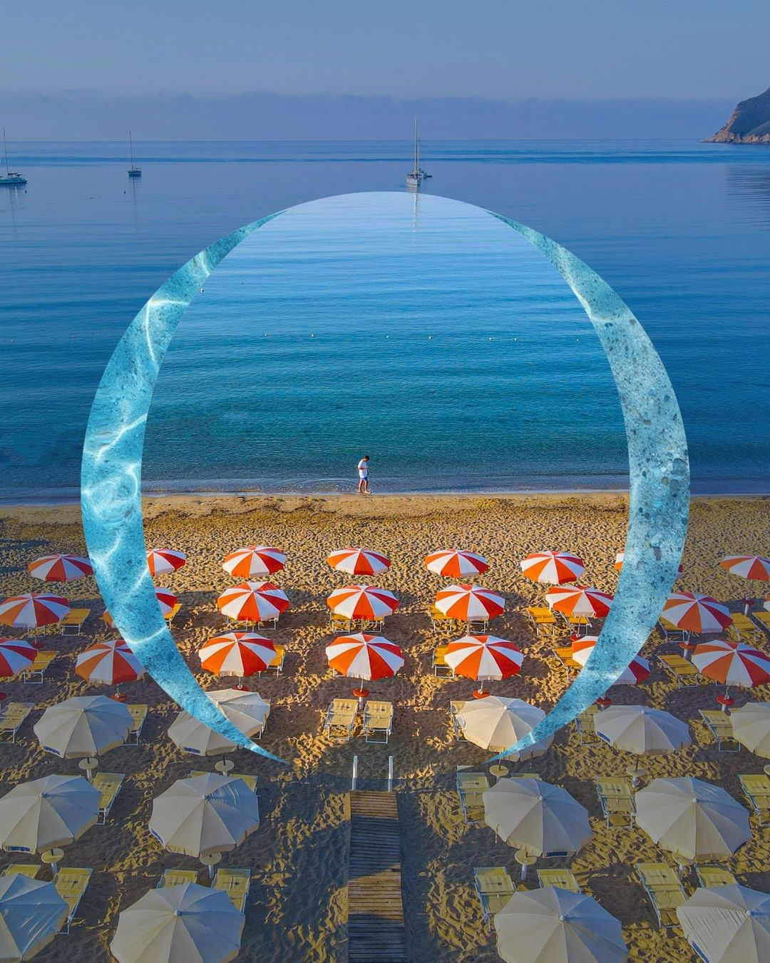 Plaża z czerwonymi i białymi parasolami, parasolami beżowymi, drewnianym przejściem i osobą na brzegu spokojnego morza.